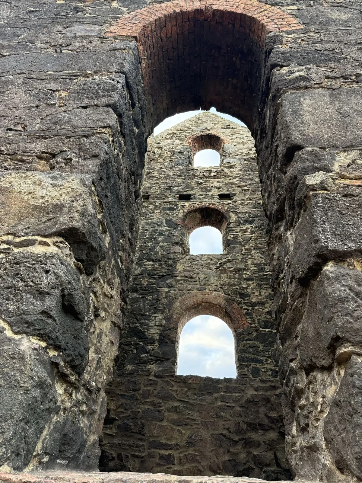 Arched windows of an engine house framed by a stone opening