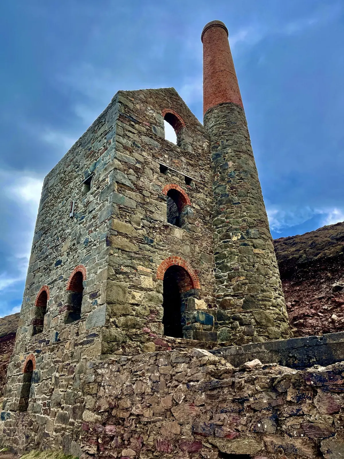 Looking up at an engine house and its red brick chimney